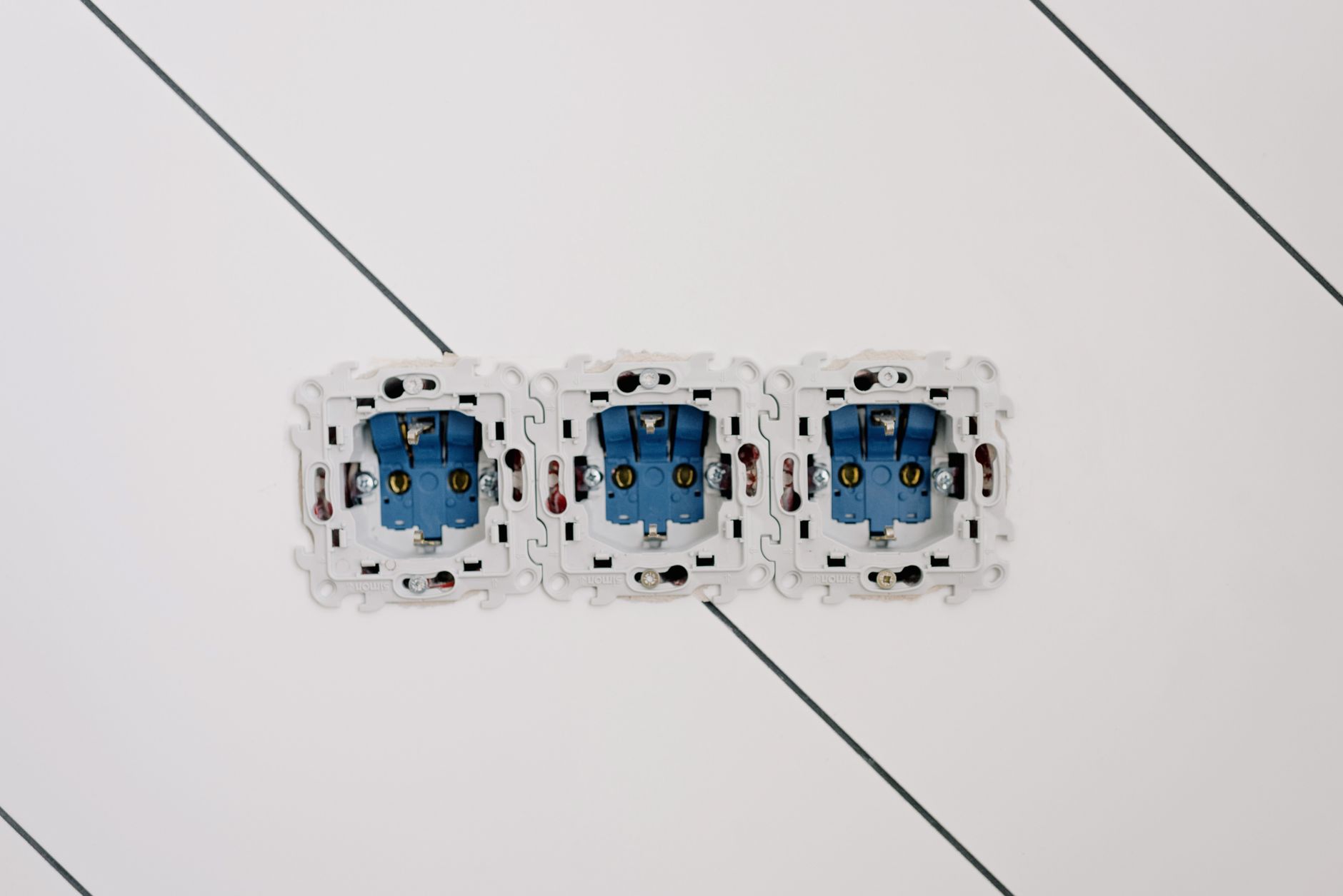 Power sockets with various connectors and bolts on wall in room at home