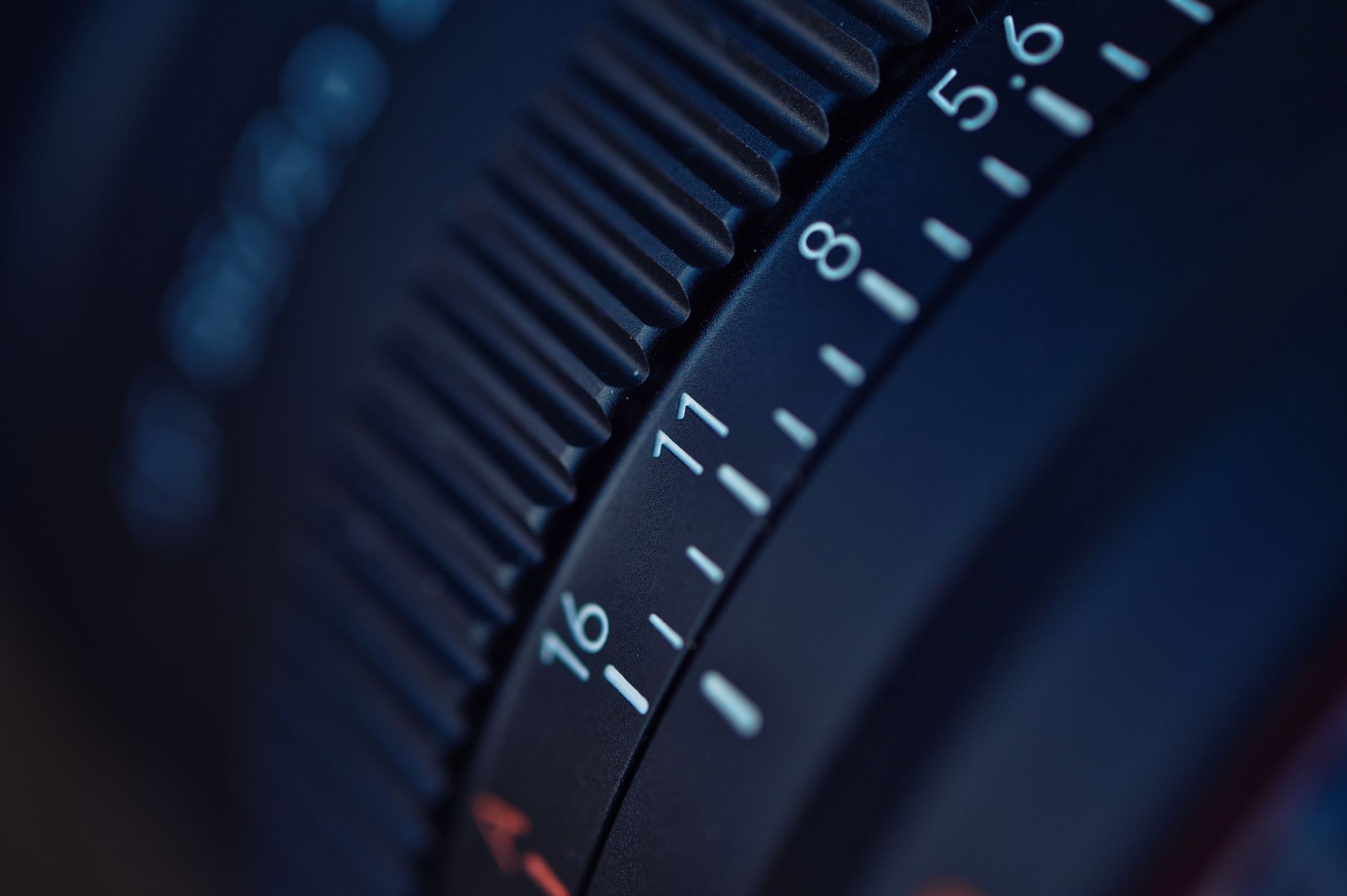 Detailed focus on a camera lens aperture ring, capturing f-stop numbers.