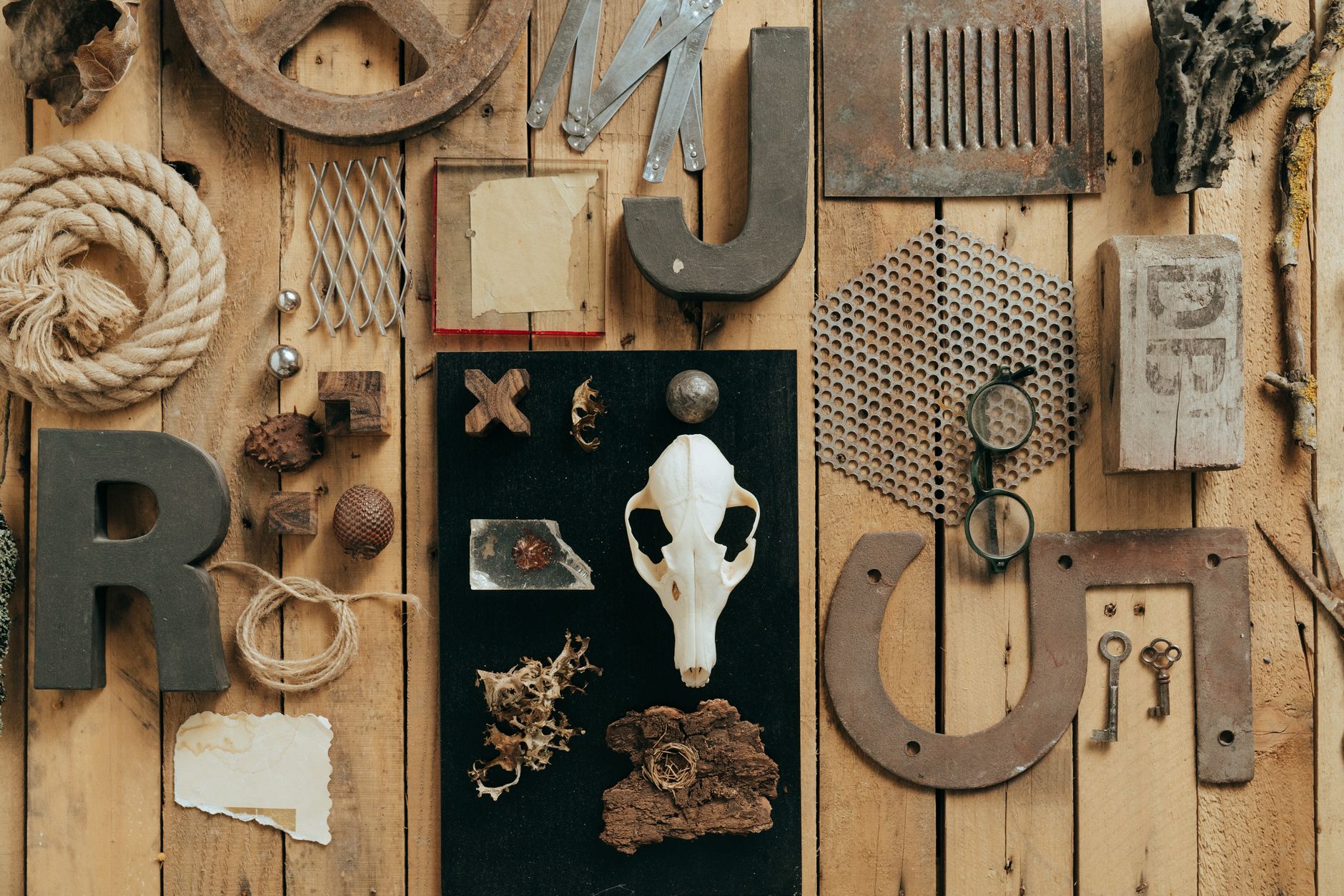 A diverse arrangement of vintage and rustic objects on a wooden background, showcasing textures and materials.