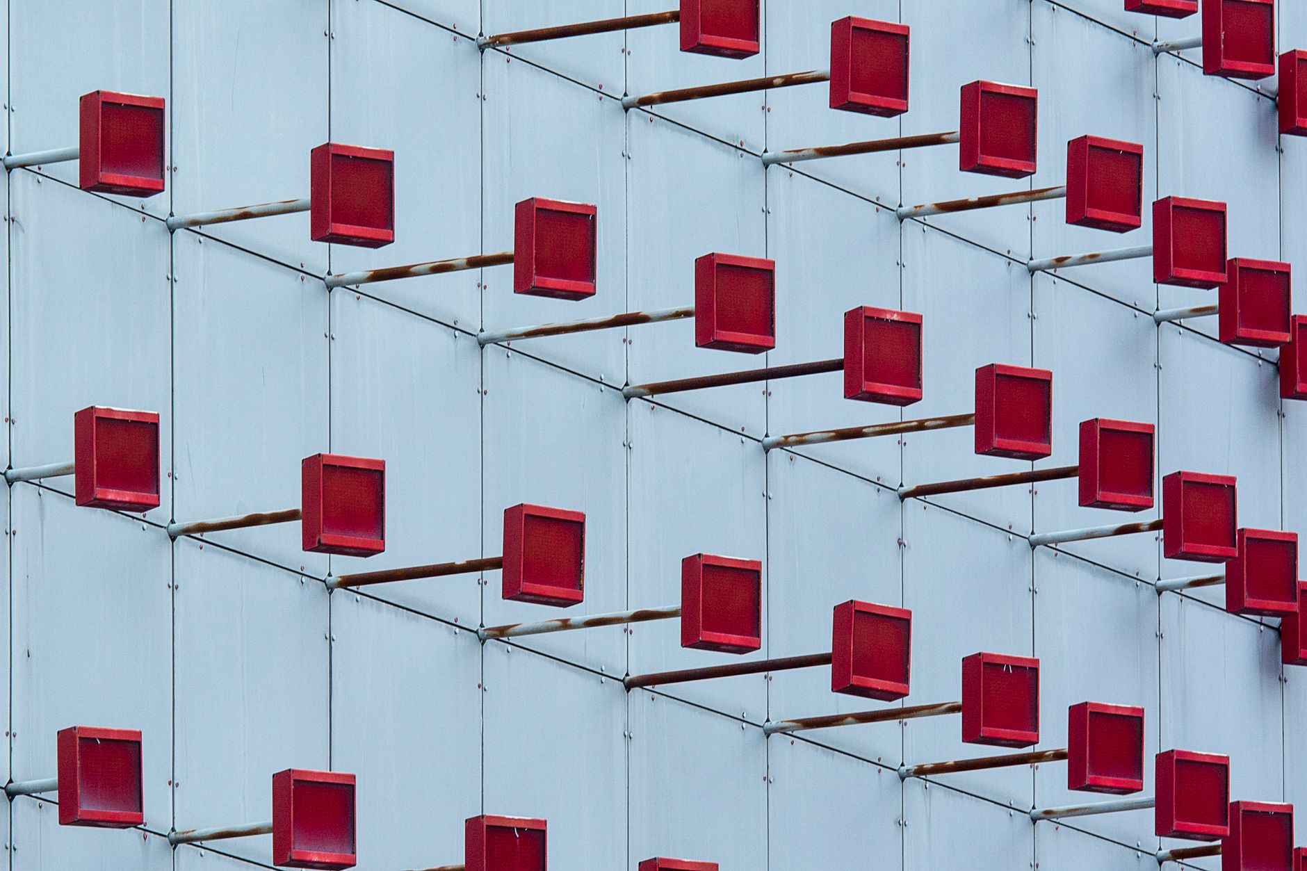 Elevated view of a unique building facade featuring red cube patterns.