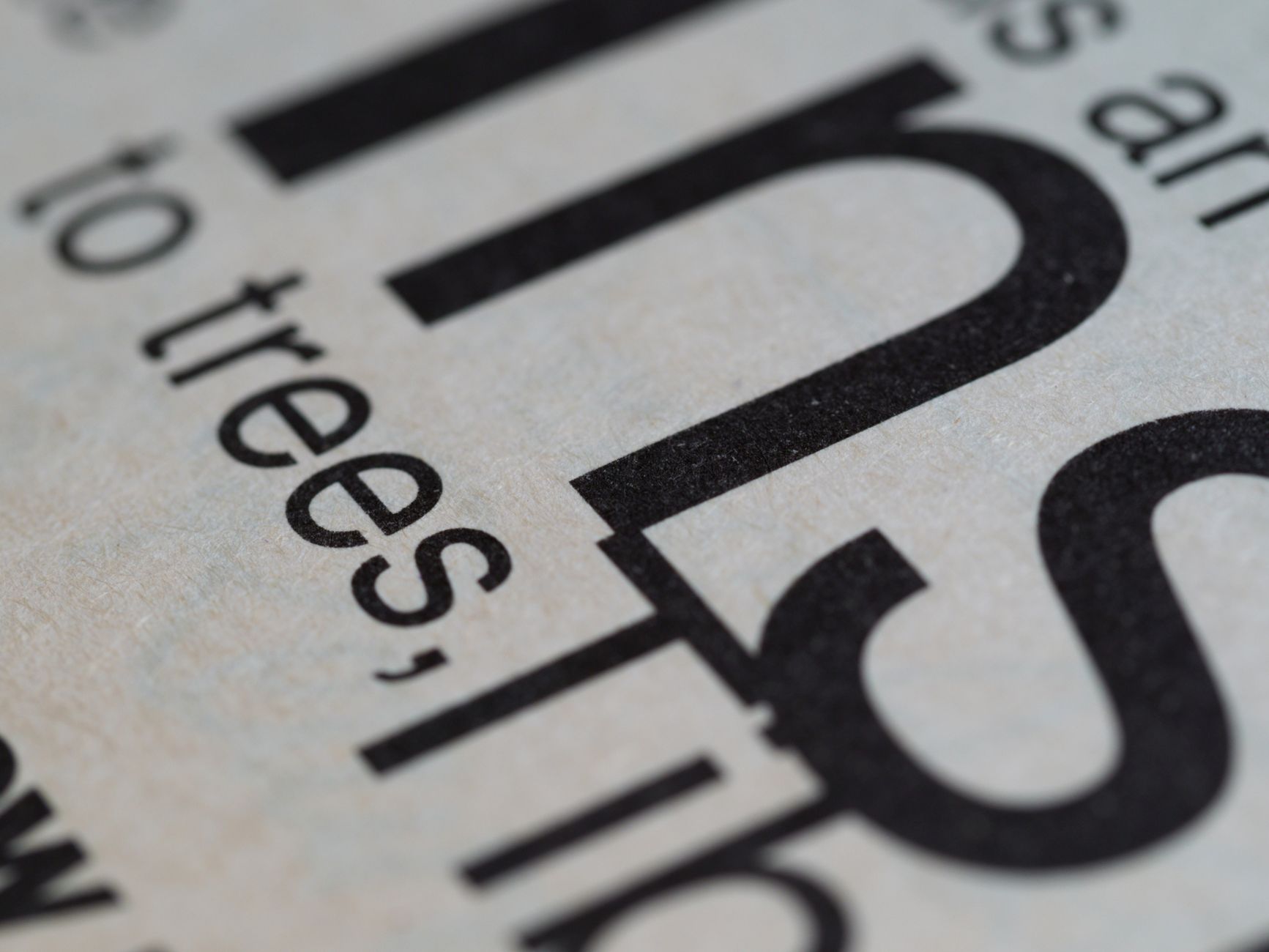 Detailed macro shot of printed text on white paper showcasing typography.