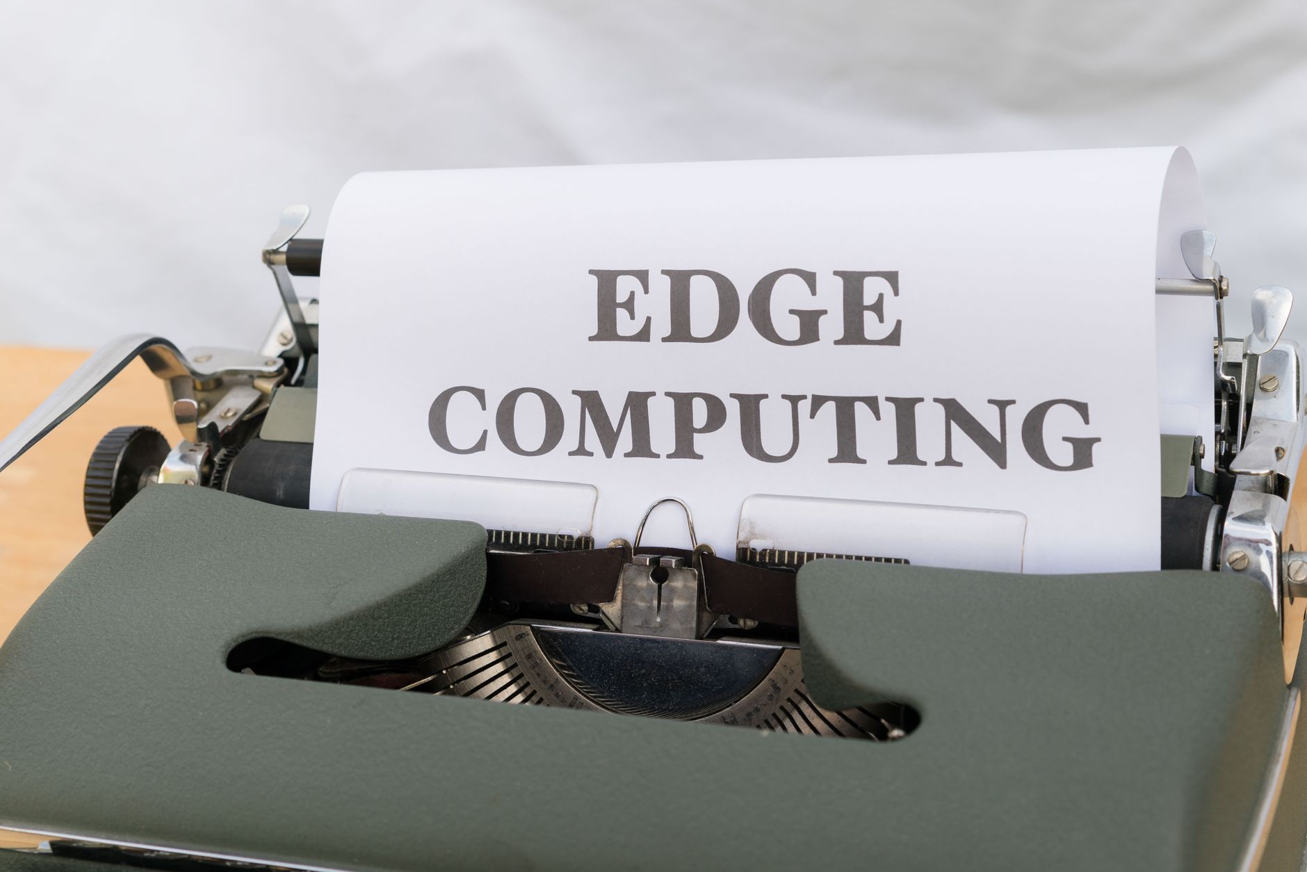 A vintage typewriter displaying the words 'Edge Computing' on paper, highlighting technological contrast.