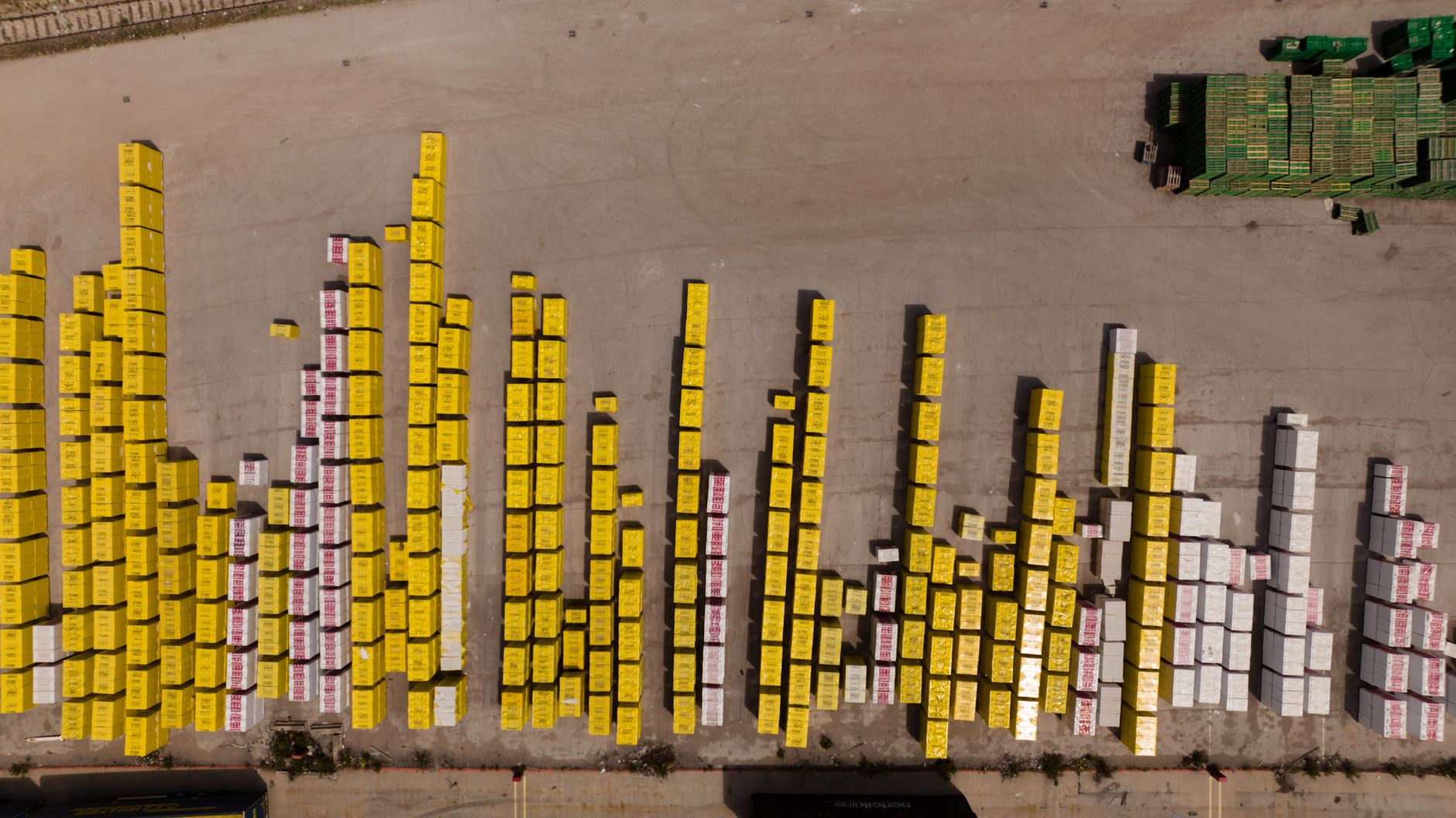 Aerial shot of colorful stacked cargo containers at a logistics depot.