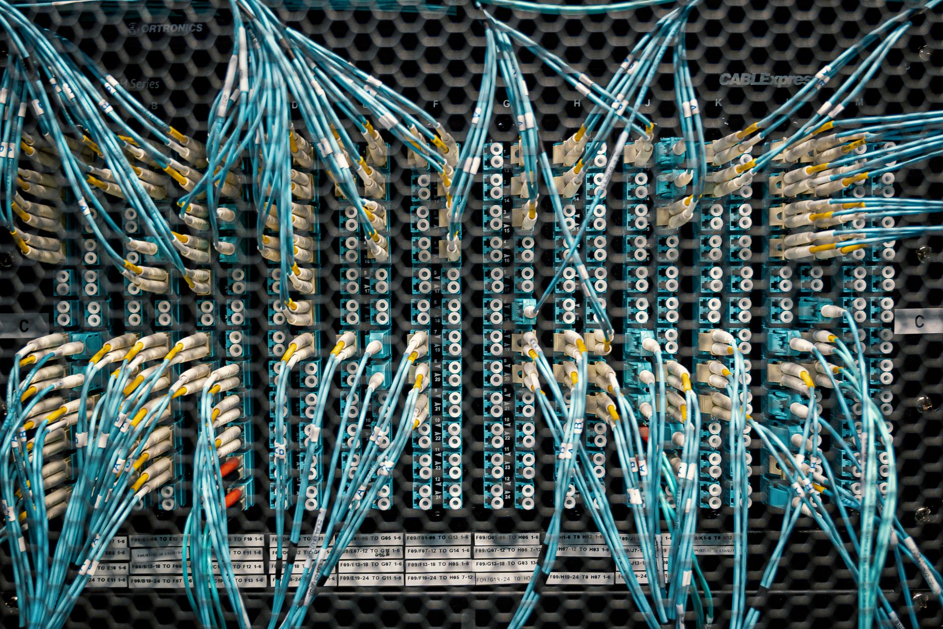 Overhead view of similar bright cables with plastic connectors in fiber optical switch