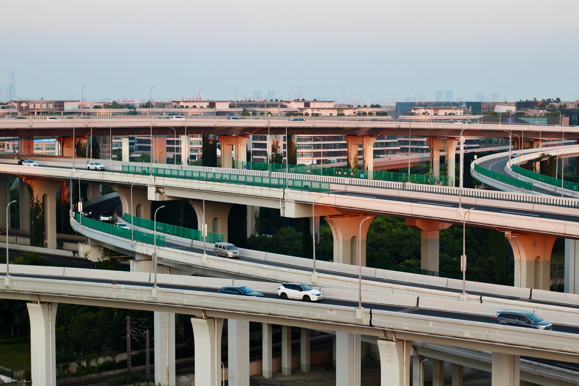 Aerial view of a modern highway interchange at dusk with flowing traffic.
