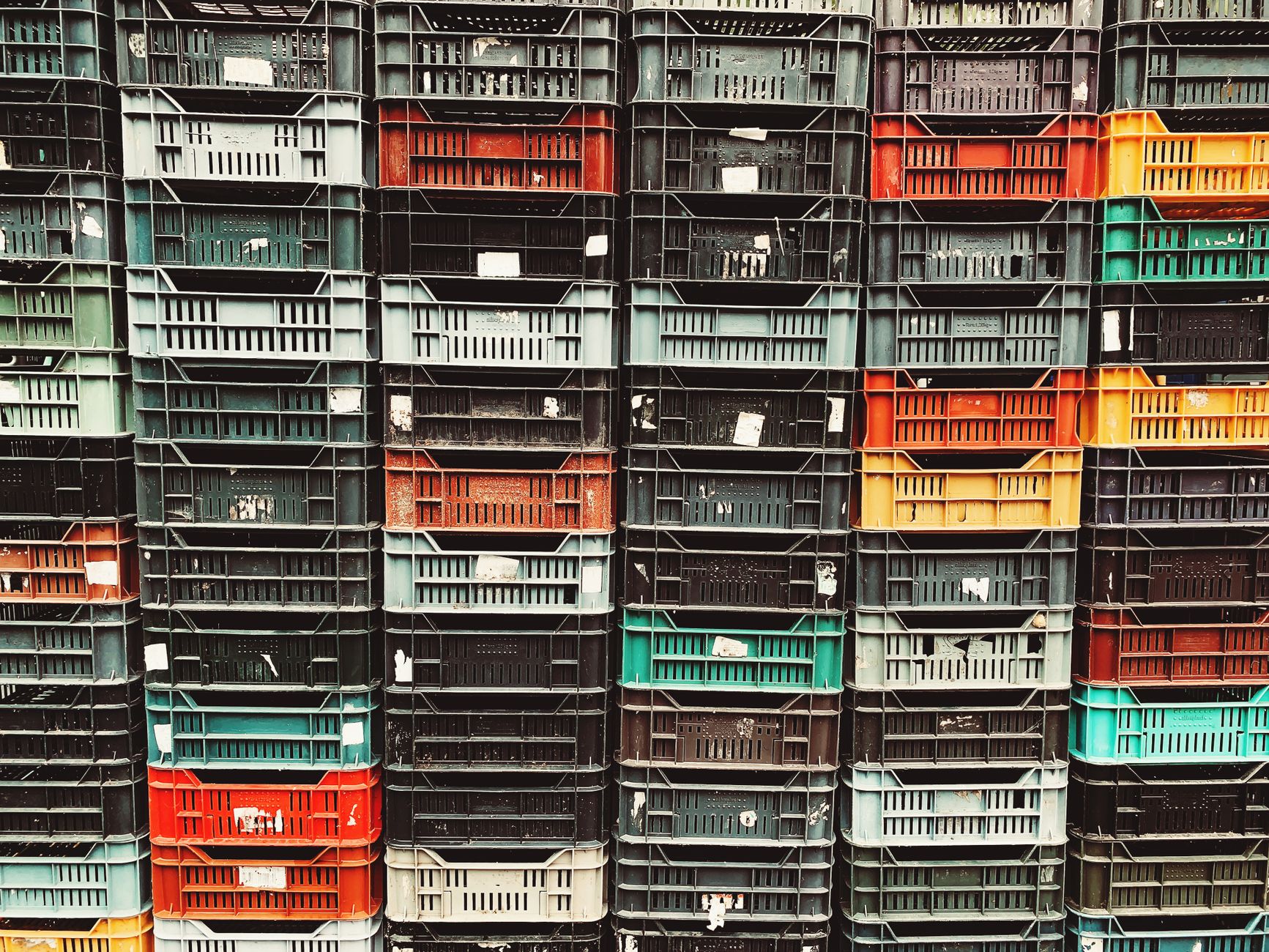 Vibrant stack of plastic storage crates showcasing various colors and textures.