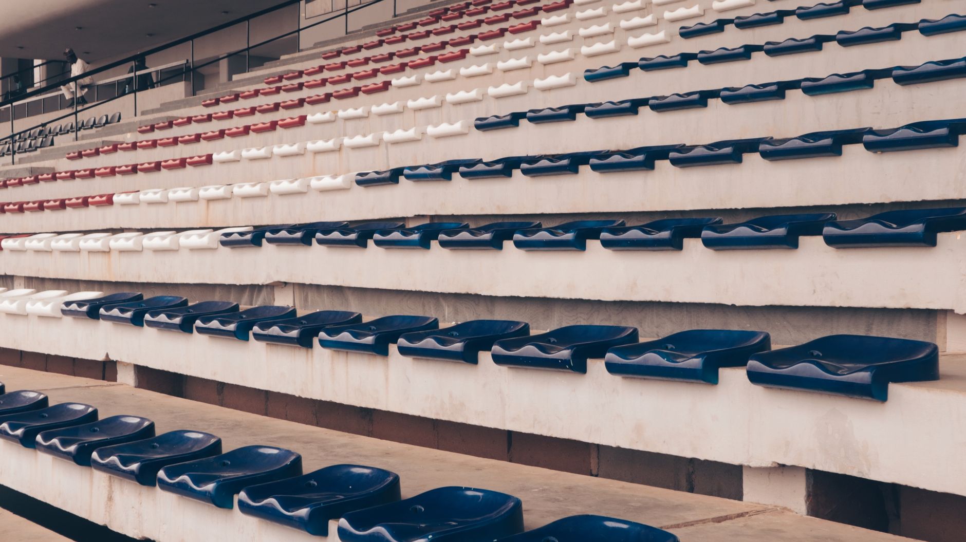 An empty stadium with red, white, and blue seats arranged in rows, offering a patriotic theme.