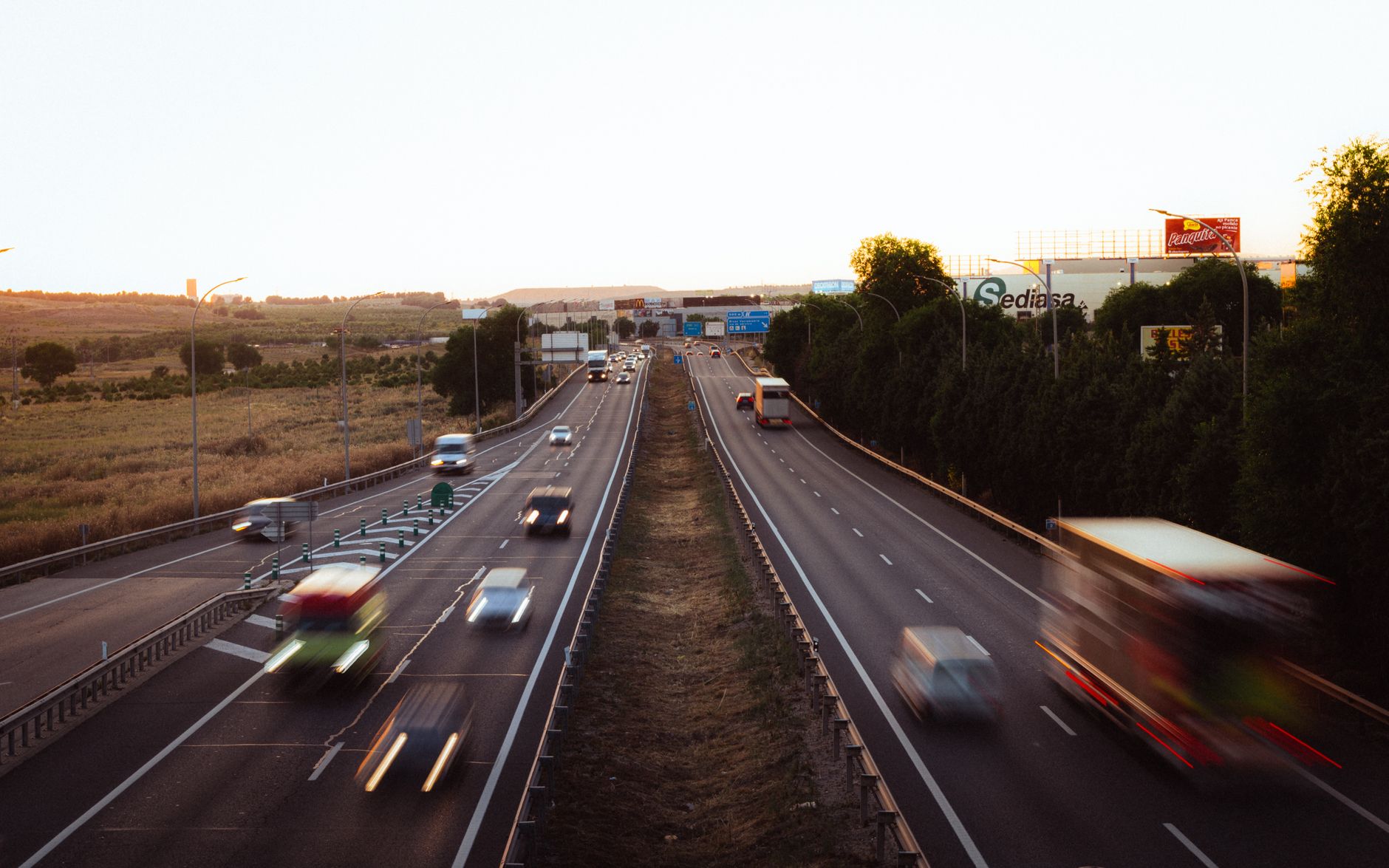 Aerial view of a busy multi-lane highway in Madrid, Spain during dusk, showcasing a dynamic travel scene.
