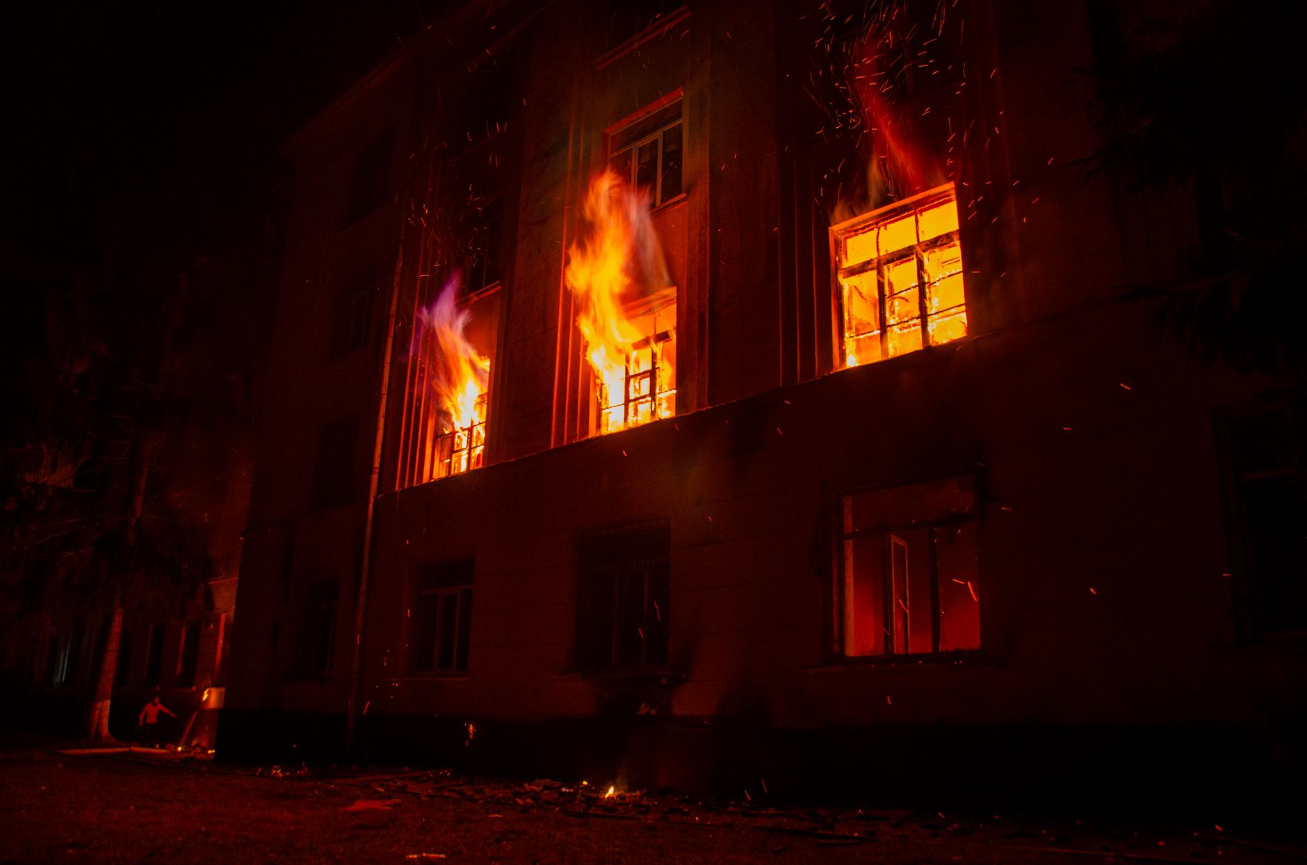 A blazing fire engulfs a building in Lviv at night, creating a dramatic scene with bright flames.