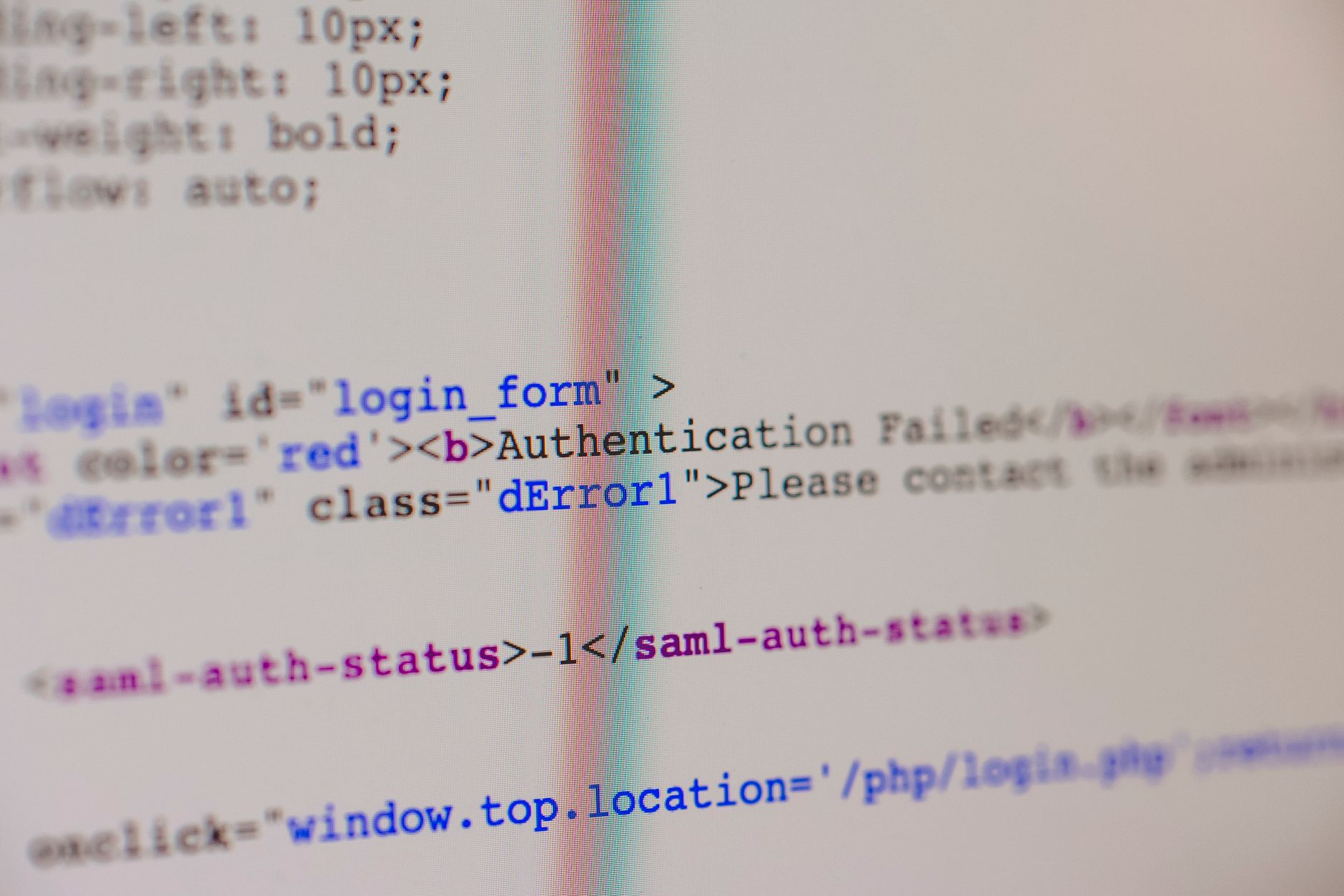 Close-up of HTML and PHP code on screen showing error message and login form data.