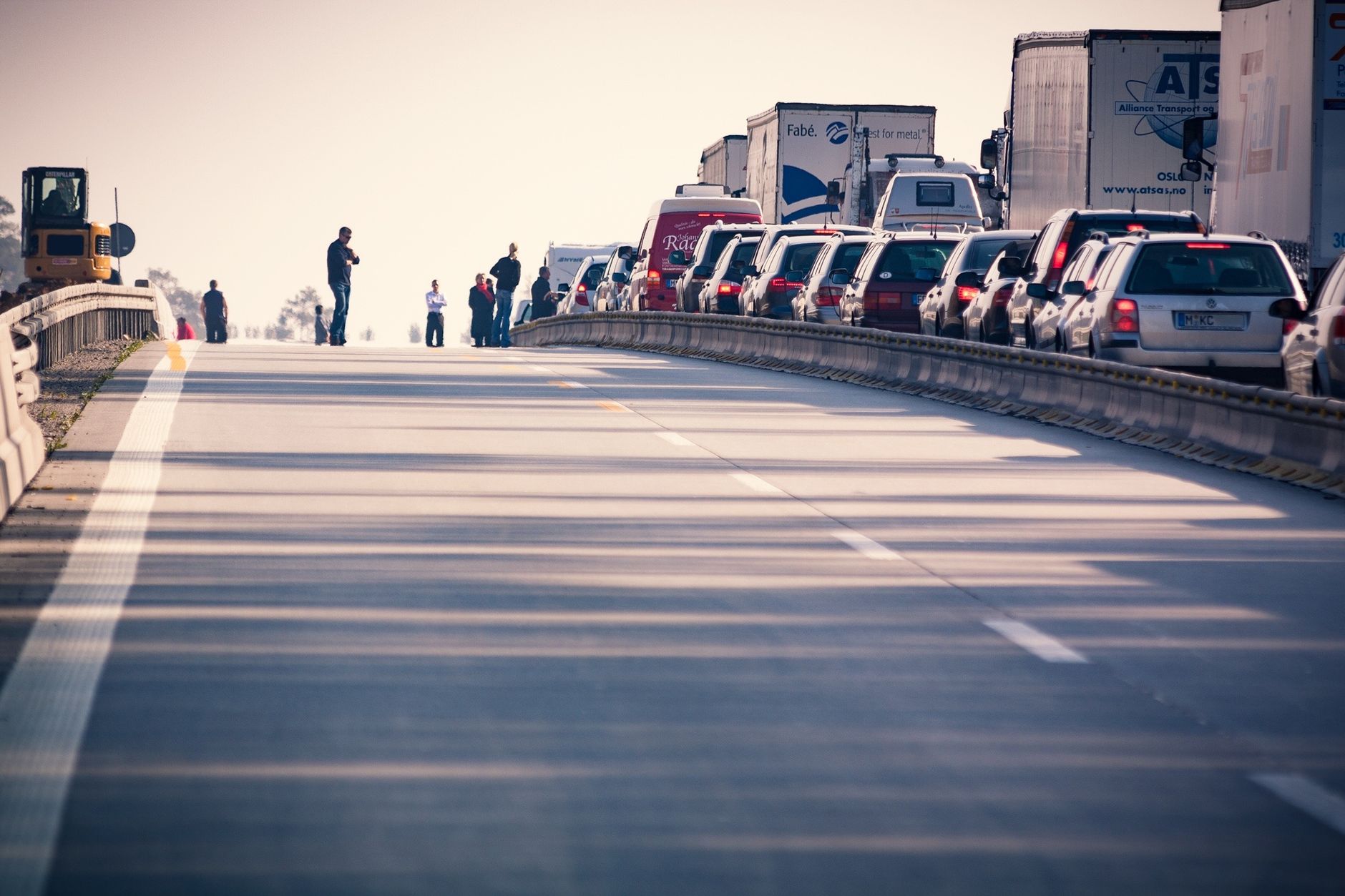 A congested highway with cars and trucks in a traffic jam during daylight.