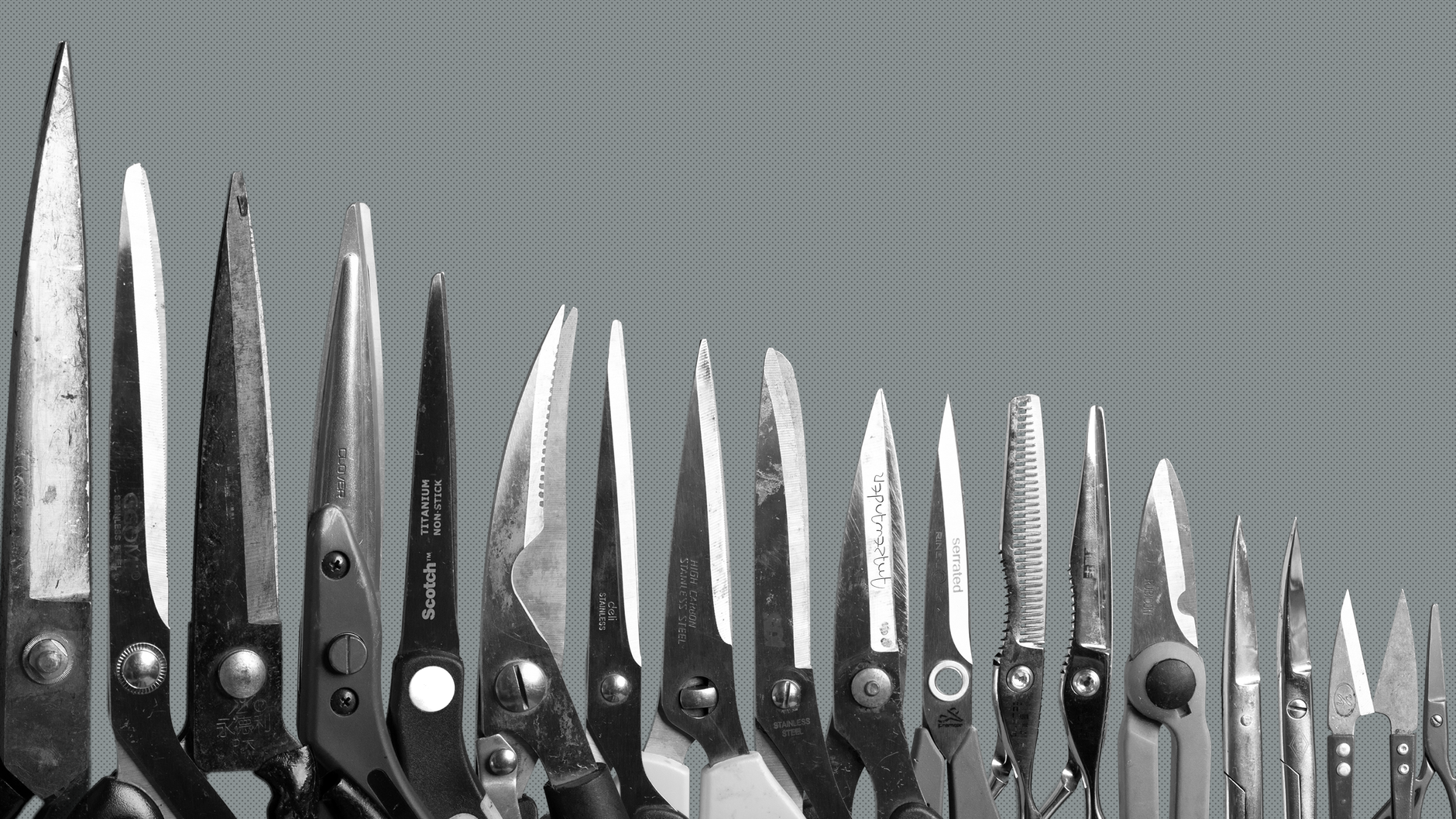 A variety of sharp cutting tools arranged side by side on a plain background.