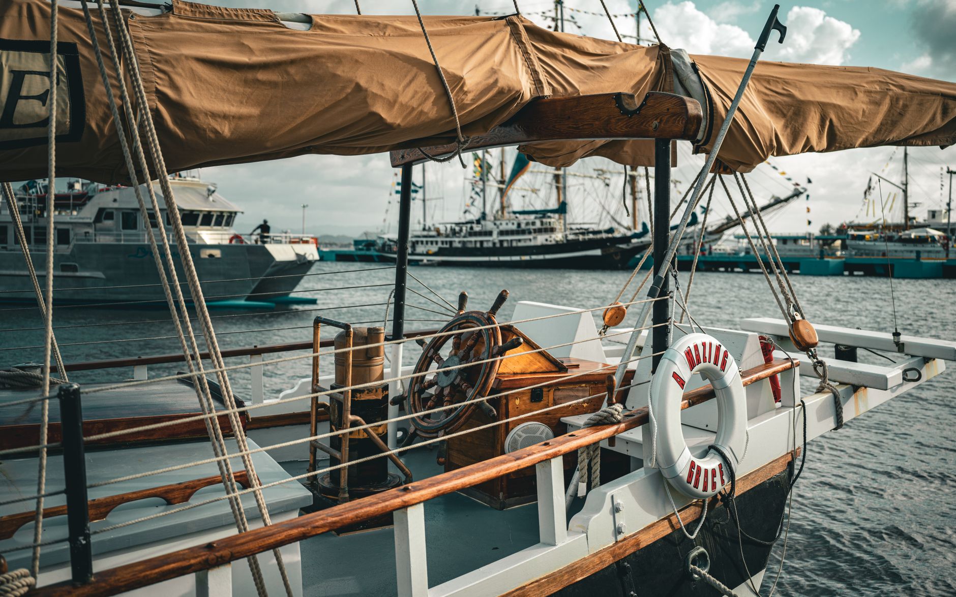 A rustic sailboat docked in a bustling maritime harbor, showcasing nautical charm.