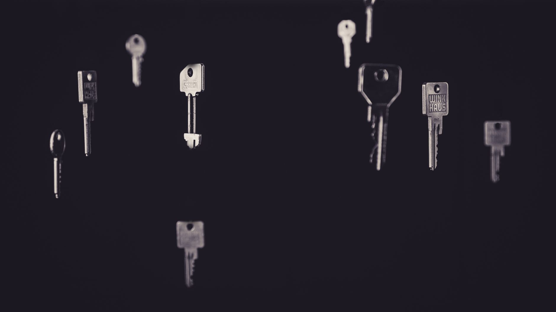 Artistic display of floating metallic keys in a dark, minimalist setting.