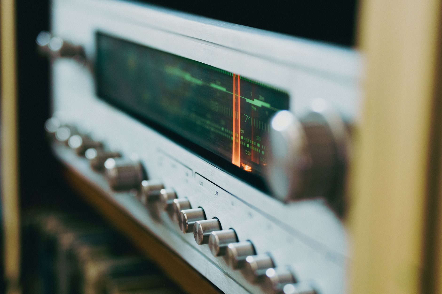 Close-up of an antique radio tuner with knobs and a retro display, evoking a classic analog feel.