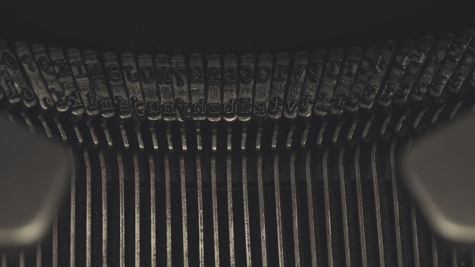 Detailed view of metallic typebars on an old typewriter highlighting its mechanical complexity.
