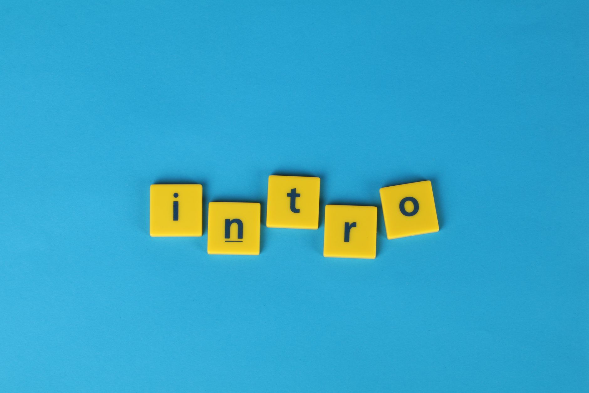 Yellow letter tiles spell 'intro' on a vibrant blue background, ideal for creative projects.