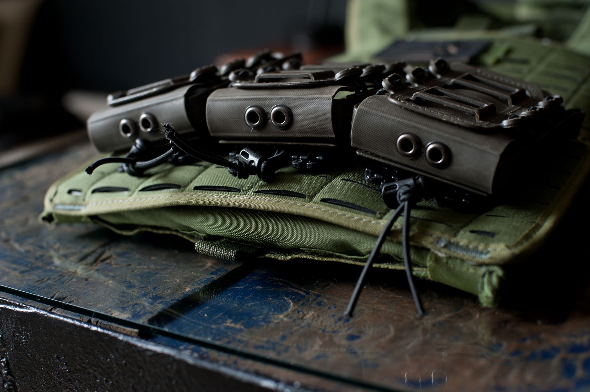Close-up image of tactical gear and pouches mounted on a green vest.