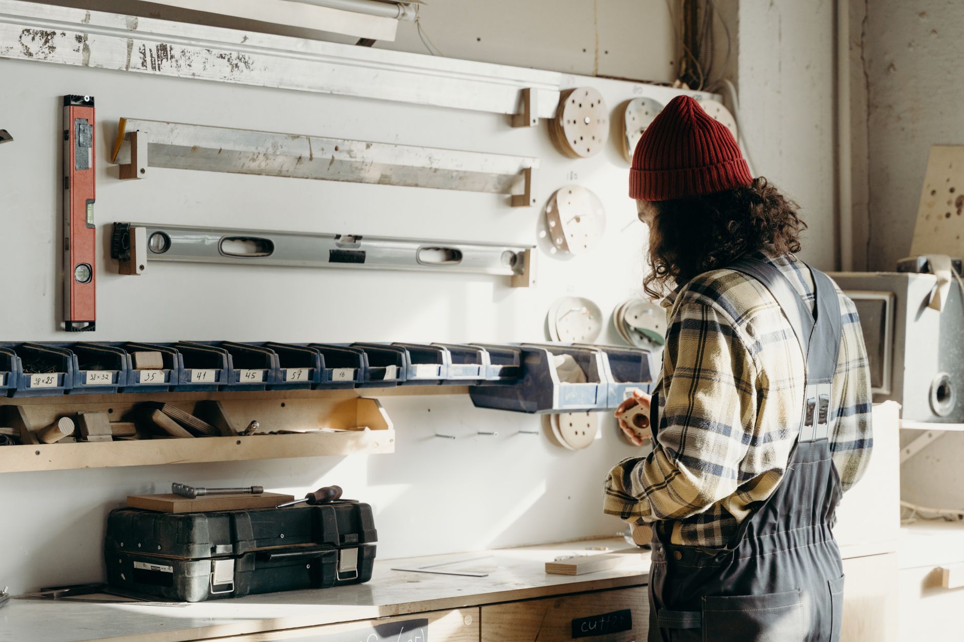 A dedicated carpenter working in a well-organized workshop filled with tools and materials.