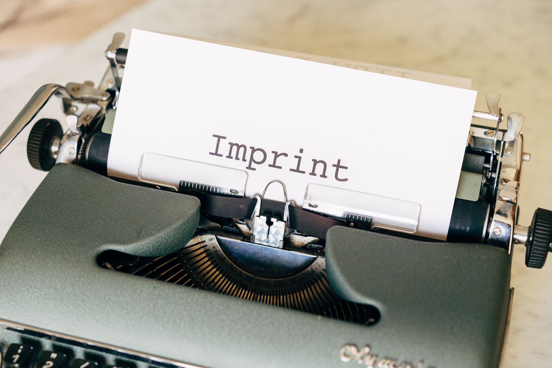 Close-up of a vintage typewriter with the word 'Imprint' on paper, evoking a classic retro feel.