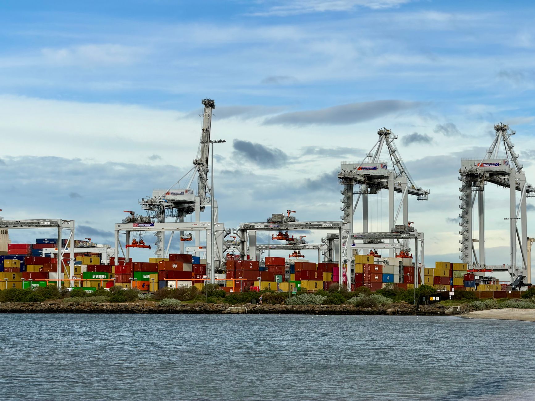 Colorful shipping containers and cranes at a bustling port in Victoria, Australia.