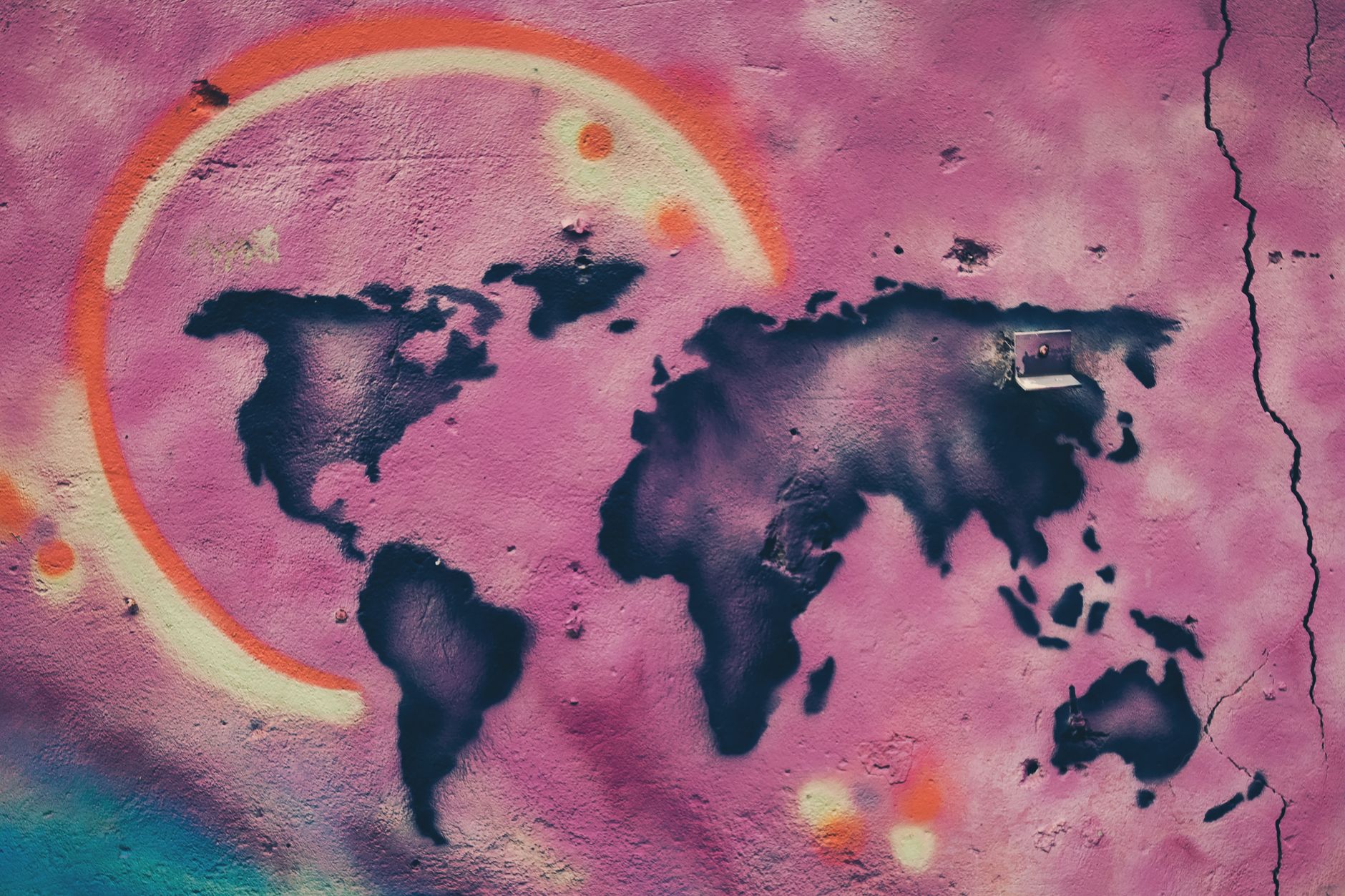 Colorful graffiti art depicting a world map on a cracked urban wall in Jerusalem.