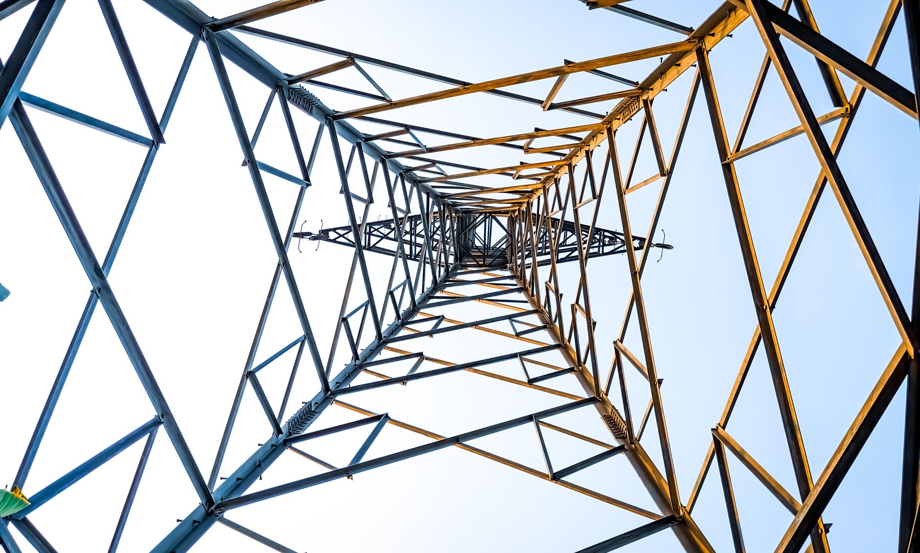 Looking up at a geometric power transmission tower in Depok, Indonesia.
