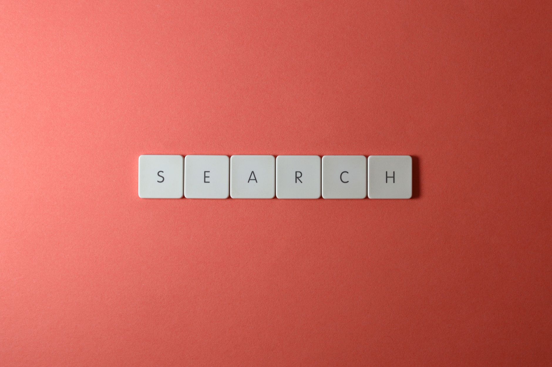 White keyboard keys spelling 'search' on a bold red surface, conceptual design with copyspace.